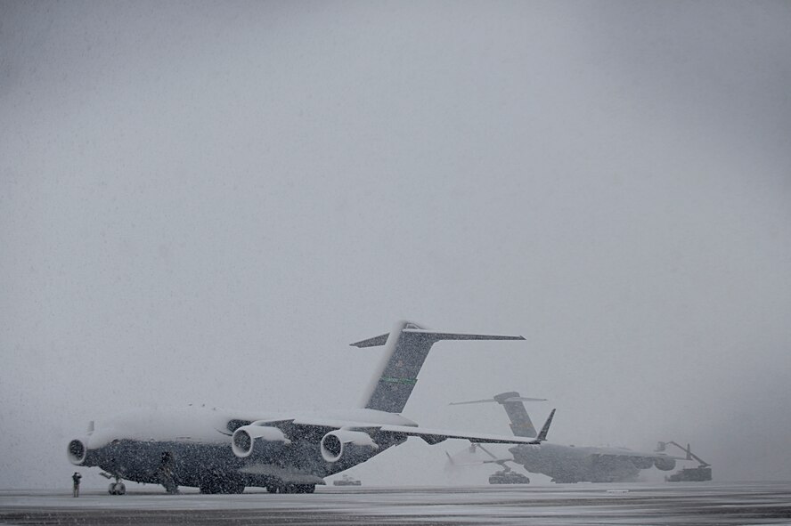Personnel at Joint Base Andrews, Md., de-ice C-17 Globemaster III aircraft on the flightline, March 25, 2013, during a spring snowstorm. (U.S. Air Force photo/Staff Sgt. Brittany E. Jones)