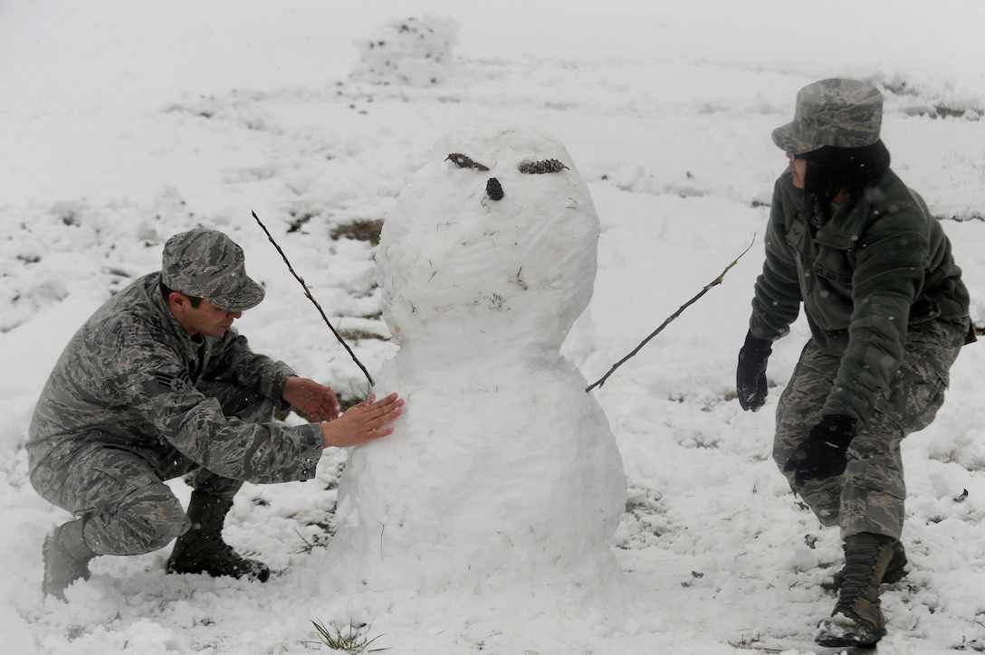 Senior Airman Edwin Santos Limon, left, and Airman 1st Class Hayley Teehera, both with Joint Base Andrews, Md. Honor Guard, take a break to build a snowman, March 25, 2013. The spring snowstorm is forecasted to bring up to five inches of snow to the local area.  (U.S. Air Force photo/Staff Sgt. Brittany E. Jones)