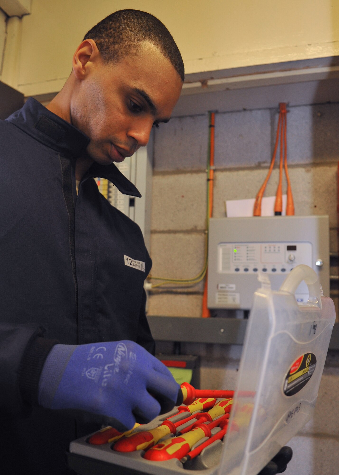 Tech. Sgt. Dramel Jackson, 100th Civil Engineer Squadron Electrical Systems NCO in charge electrician from New Haven, Conn., selects a tool to use prior to working on an electrical panel March 22, 2013, at RAF Mildenhall, England. The electrical shop remains on stand-by 24/7 in order to provide immediate support in the event of an electrical systems emergency. (U.S. Air Force photo by Senior Airman Jerilyn Quintanilla/Released)