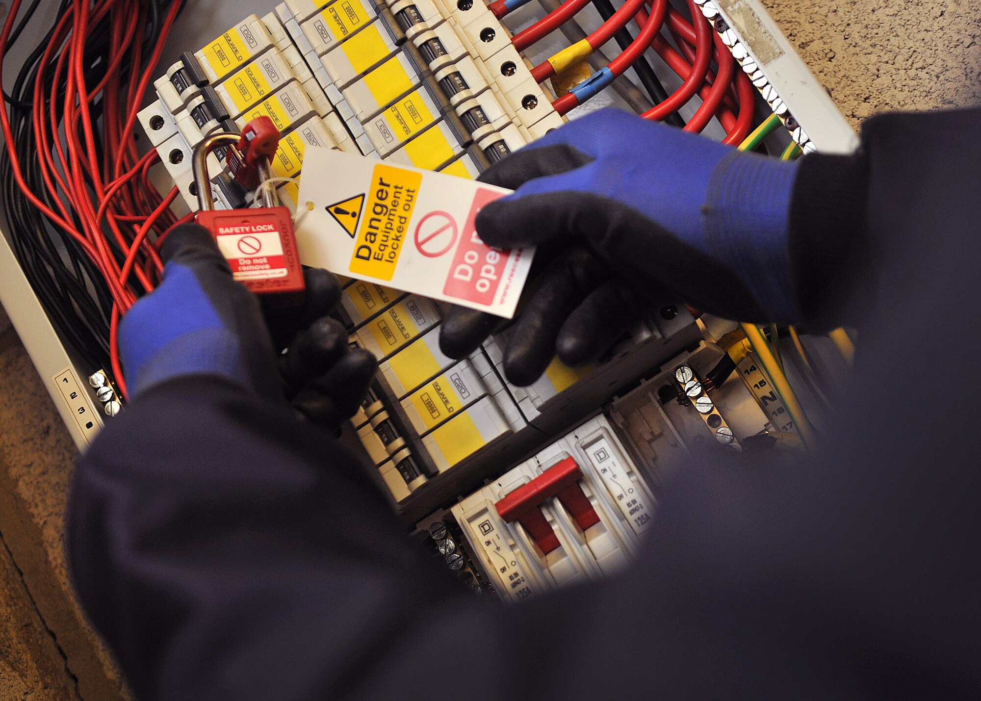 Tech. Sgt. Dramel Jackson, 100th Civil Engineer Squadron electrician from New Haven, Conn., secures a lock-out, tag-out card on an electrical panel March 22, 2013, at RAF Mildenhall, England. Lock-out, tag-out cards are used to indicate which circuits are being worked on keeping electricians safe from an electrical shock. (U.S. Air Force photo by Senior Airman Jerilyn Quintanilla/Released) 