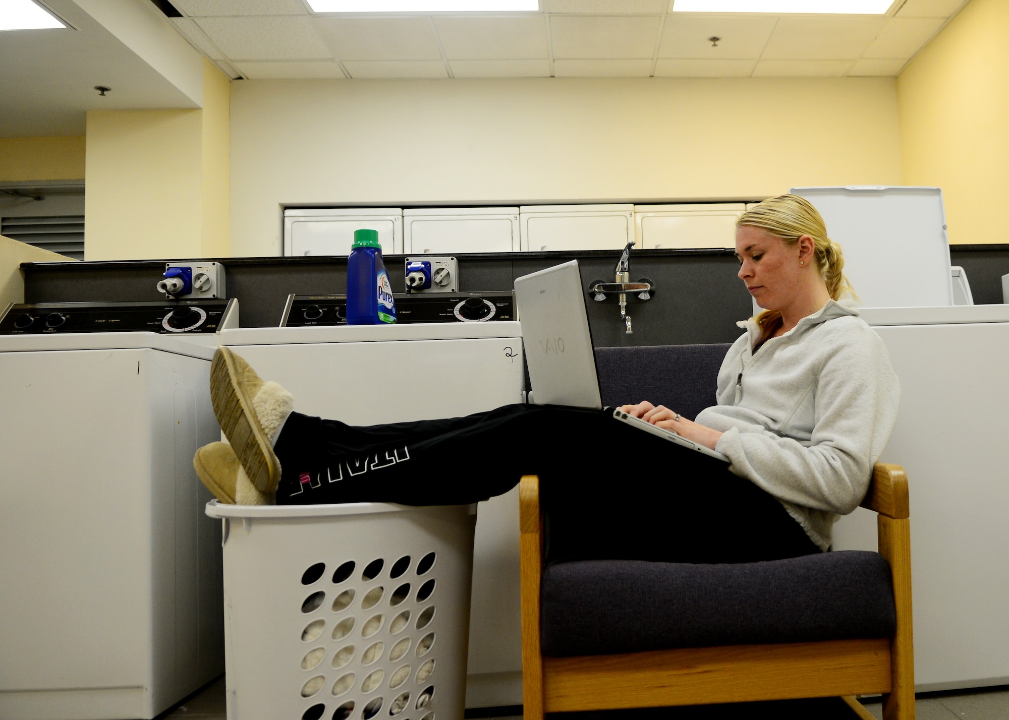 Senior Airman Kristina Englebert, 31st Mission Support Group knowledge operations manager, surfs the internet while doing laundry March 22, 2013, at Aviano Air Base, Italy. All Aviano dormitory common areas now have access to Wi-Fi as well as the Area 2 laundromat. (U.S. Air Force photo/Airman 1st Class Briana Jones)