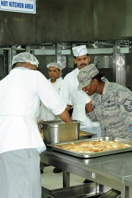 Master Sgt. Rayshawnda Davis, 386th Expeditionary Force Support Squadron, interacts with Third Country National employees in the Desert Winds dining facility at the 386th Air Expeditionary Wing, Southwest Asia Mar 19, 2013. Davis oversees all food operations at the 386th Air Expeditionary Wing and the 387th Air Expeditionary Group.
