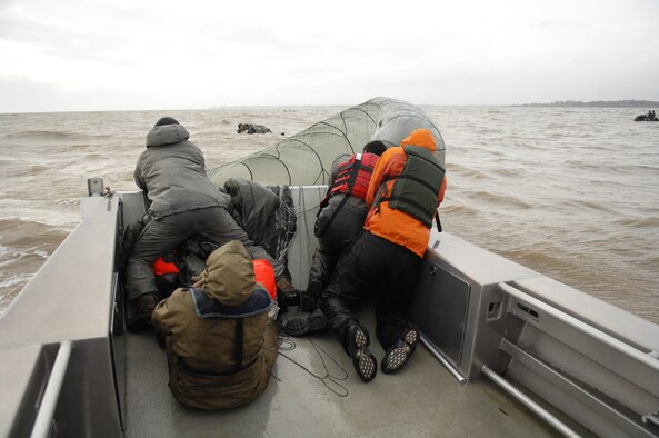 Airmen from the 321st Special Tactics Squadron retrieve a parachute during a water-landing exercise March 15, 2013, off the coast of Ipswich, England. Five Airmen, along with an inflatable motor raft were dropped from a C-130 for the exercise. The 321st STS conducted a week-long jump exercise to keep its members proficient in their ability to tactically insert into various combat zones. (U.S. Air Force photo by Airman 1st Class Dillon Johnston/Released)