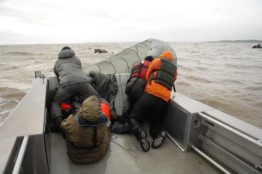 Airmen from the 321st Special Tactics Squadron retrieve a parachute during a water-landing exercise March 15, 2013, off the coast of Ipswich, England. Five Airmen, along with an inflatable motor raft were dropped from a C-130 for the exercise. The 321st STS conducted a week-long jump exercise to keep its members proficient in their ability to tactically insert into various combat zones. (U.S. Air Force photo by Airman 1st Class Dillon Johnston/Released)