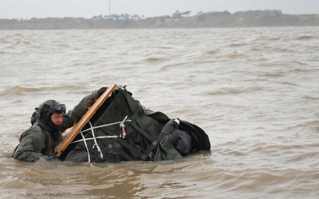 Front, Chief Master Sgt. William Markham, 352nd Special Operations Group command chief, grabs on to a pallet containing an inflatable motor raft during a water-landing exercise March 15, 2013, off the coast of Ipswich, England. Once in the water, Airmen worked to right the boat and climb in to ride back to shore. (U.S. Air Force photo by Airman 1st Class Dillon Johnston/Released)