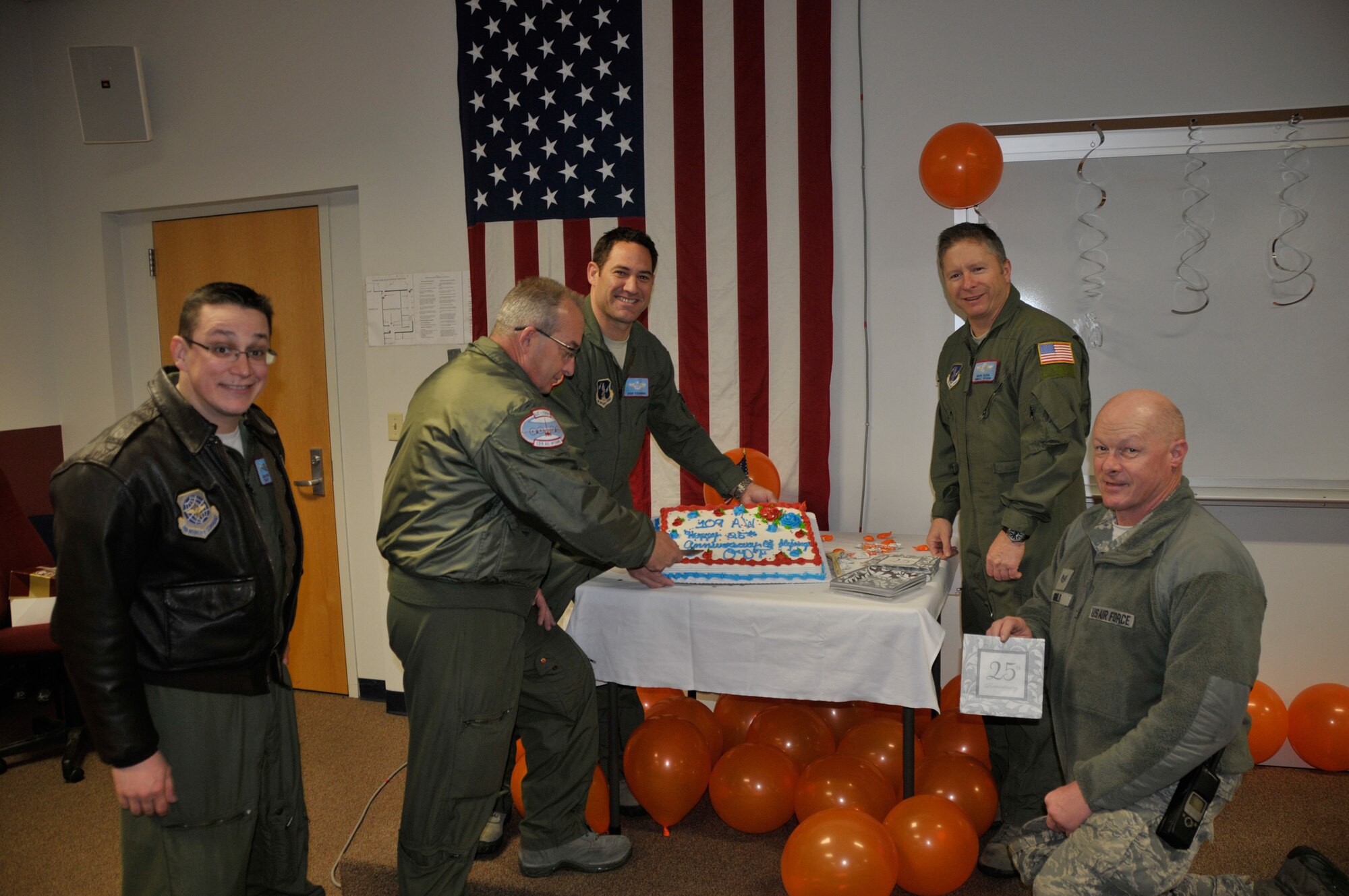 Crew members from 109th wing cut a cake in celebration of the unit's 25th year flying missions to Antarctica in support of Operation Deep Freeze at Stratton Air National Guard Base on March 21, 2013. (Photo by Master Sgt. Willie Gizara)