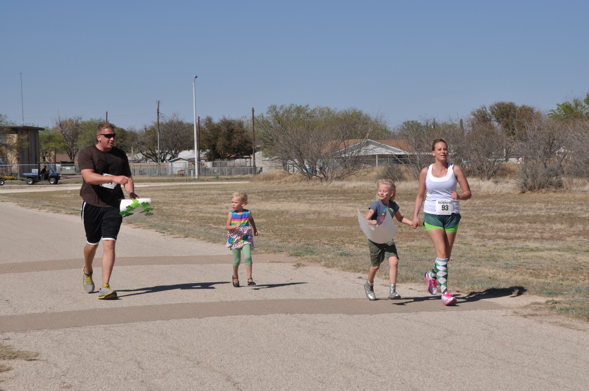 GOODFELLOW AIR FORCE BASE, Texas – The Smith family runs the last leg of the St. Patrick’s Day Run together on the Kiowa Trail here March 15. Staff Sgt. Dain Smith, St. Patrick’s Day Run participant, finished the race earlier and went back with his children to support his wife. (U.S. Air Force photo/ Airman 1st Class Joshua Edwards)
