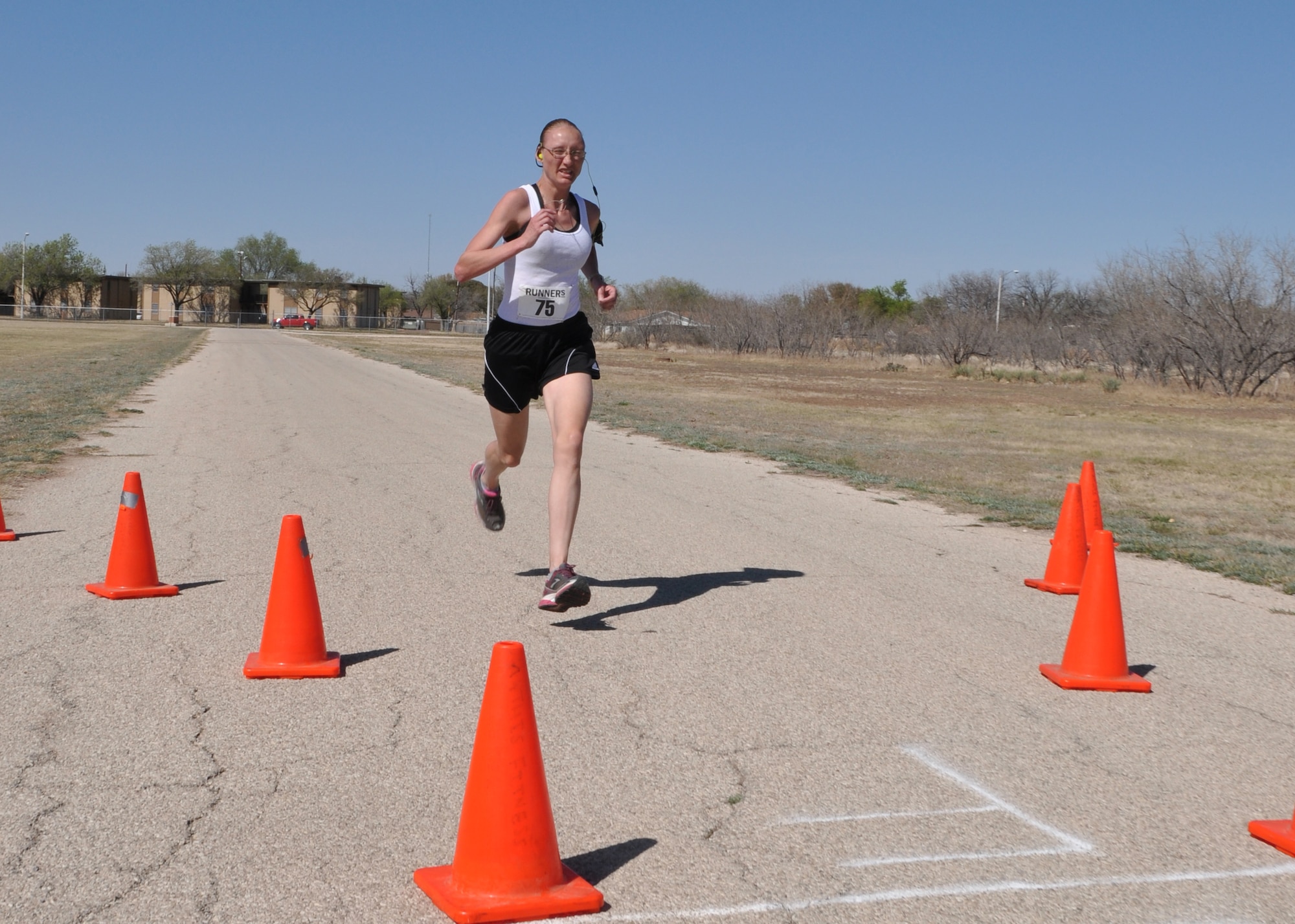 GOODFELLOW AIR FORCE BASE, Texas – Army Staff Sgt. Shannon Corona, Army 344th Military Intelligence Battalion student, is the first person to cross the finish line for the St. Patrick’s Day Run on the Kiowa Trail here March 15. Corona finished her three and a half mile run with a time of 19 minutes and 46 seconds. (U.S. Air Force photo/ Airman 1st Class Joshua Edwards)