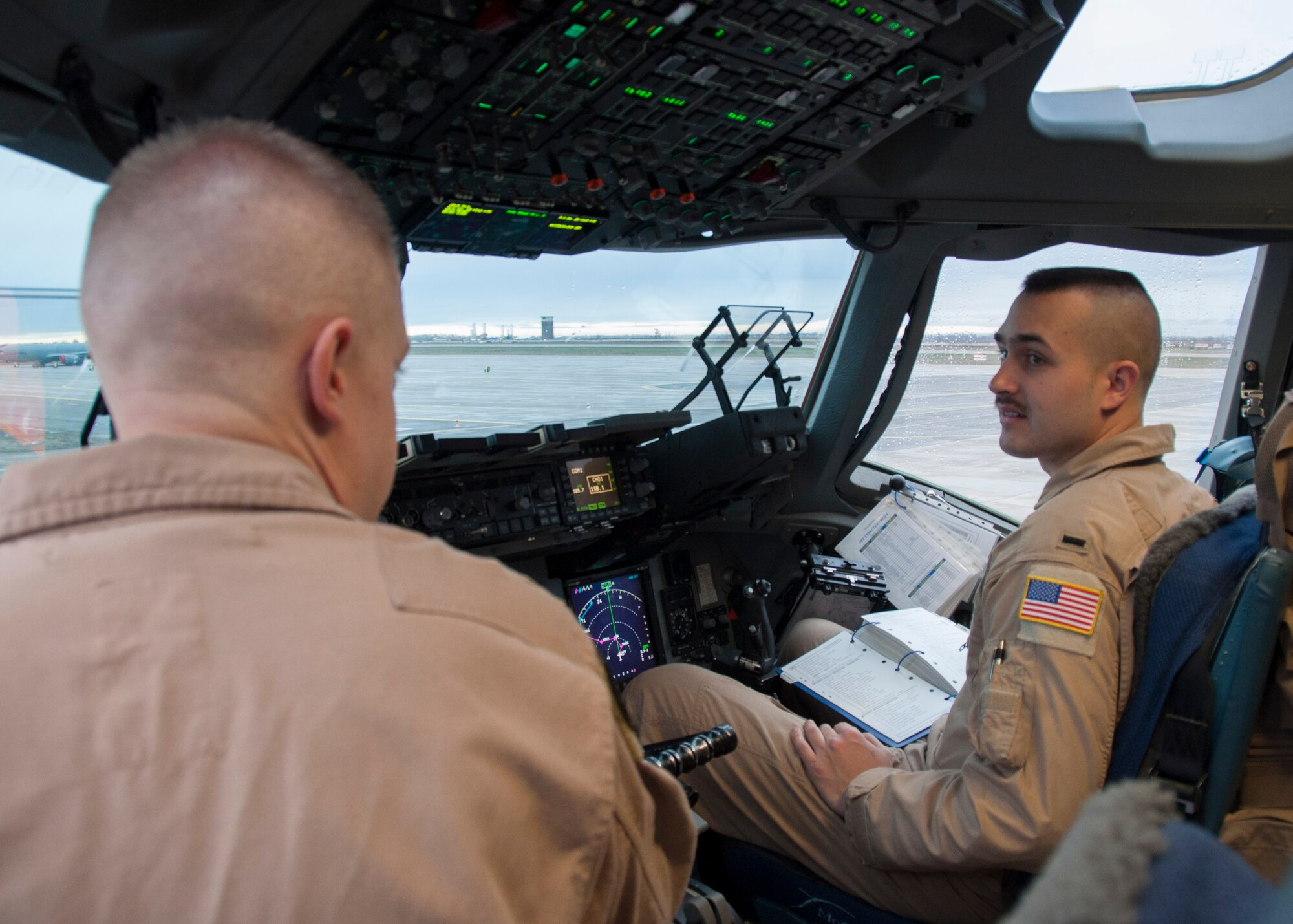 Right, 1st Lt. Matt Tolentino and Capt. Daniel Hewes, both 817th Expeditionary Airlift Squadron Detachment 1 pilots, discuss flight plans prior to taking off for a mission March 22, 2013, at Transit Center at Manas, Kyrgyzstan. Most missions for C-17 aircrews at the Transit Center can last between 10 and 13 hours. (U.S. Air Force photo/Tech. Sgt. Rachel Martinez)
