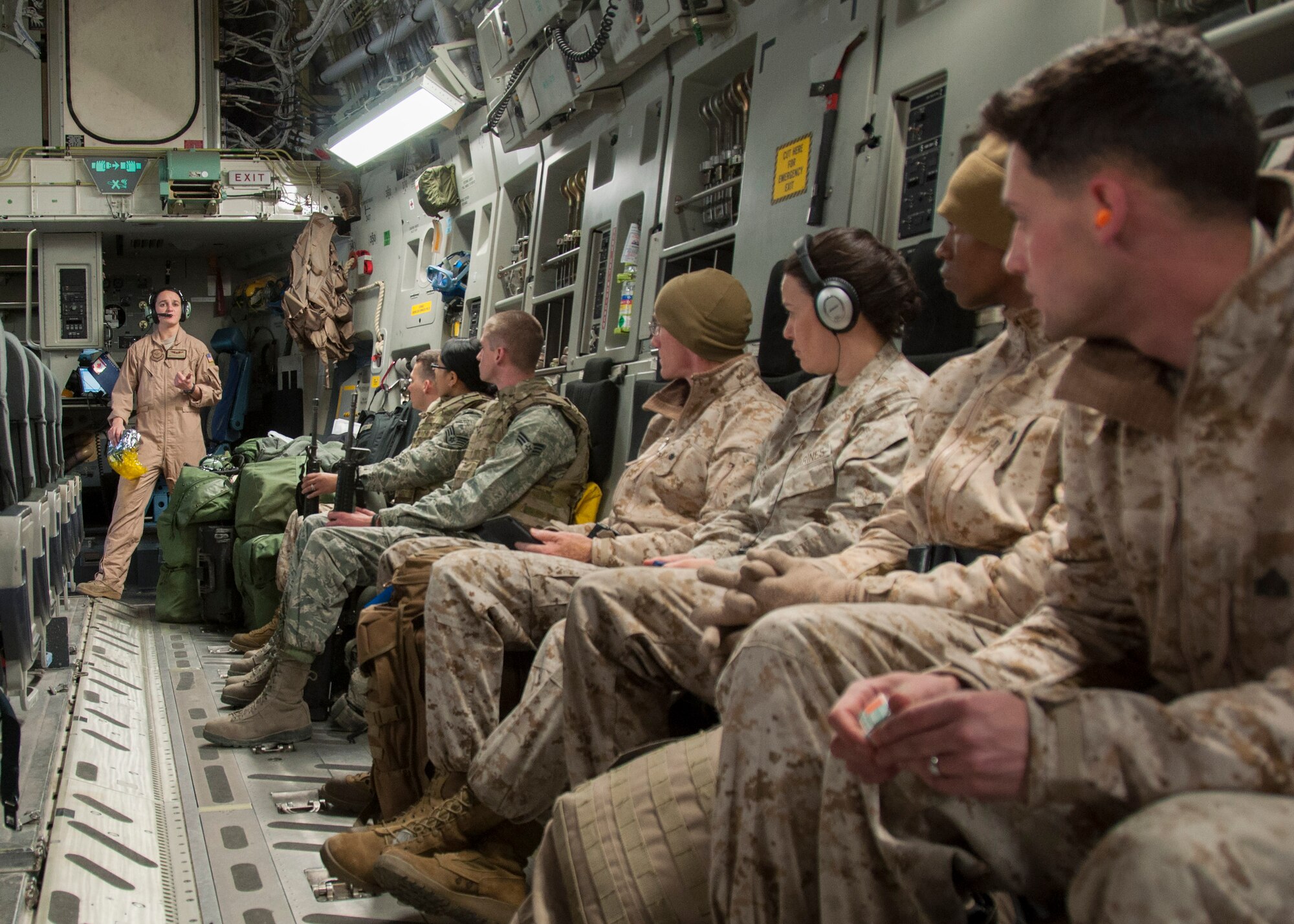 Passengers aboard a C-17 Globemaster III aircraft listen as Senior Airman Casey Jackson, 817th Expeditionary Airlift Squadron Detachment 1 loadmaster, gives a safety briefing prior to departure March 22, 2013, at Transit Center at Manas, Kyrgyzstan. Jackson and the rest of the 817 EAS are deployed from McChord Air Force Base, Wash., where four different airlift squadrons rotate filling two-month deployments to the Transit Center in support of airlift and onward movement.  (U.S. Air Force photo/Tech. Sgt. Rachel Martinez)