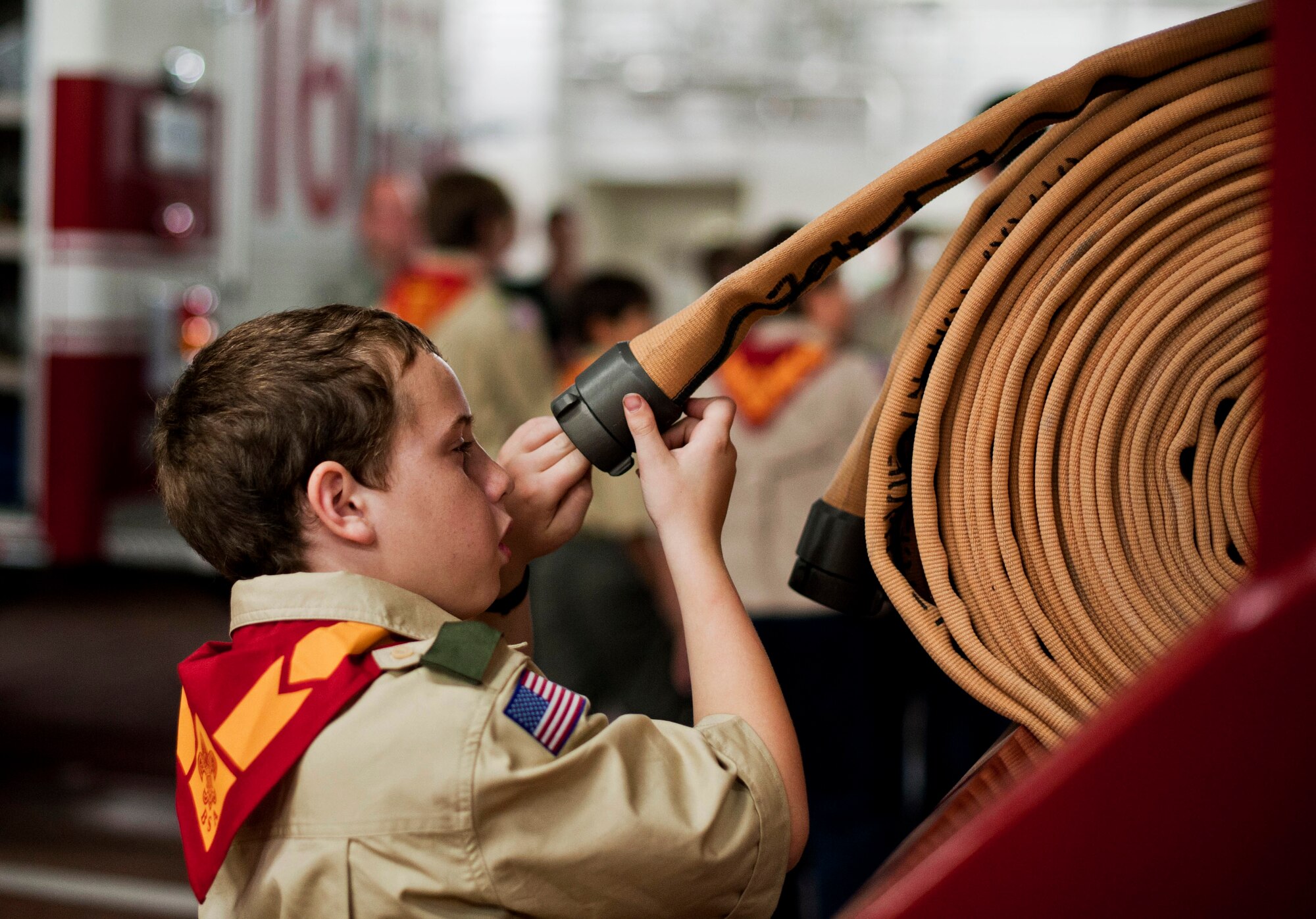 YOKOTA AIR BASE, Japan -- Thomas Allen, Boy Scouts of America Troop 45, inspects a water hose, March 20, 2013, at Yokota Air Base, Japan.  All members got to explore, try on equipment, and learn about what 374th Civil Engineer Squadron Fire Protection does every day. (U.S. Air Force photo by Airman 1st Class Meagan Schutter)  