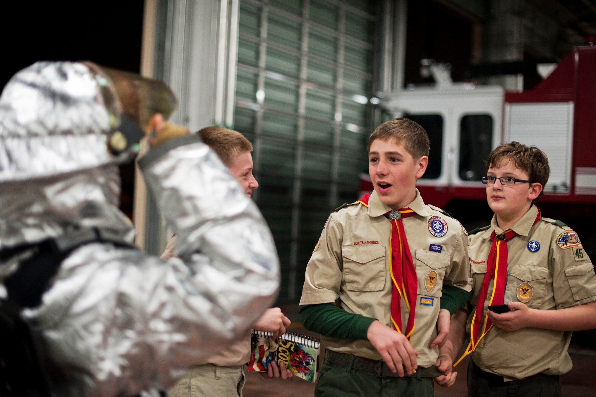 YOKOTA AIR BASE, Japan -- Scouts from Boy Scouts of America Troop 45 watch as a fellow boy scout dons turn-out gear March 20, 2013, at Yokota Air Base, Japan. Wearing the suit protects firefighters from harsh temperatures while fighting fires. (U.S. Air Force photo by Airman 1st Class Meagan Schutter)