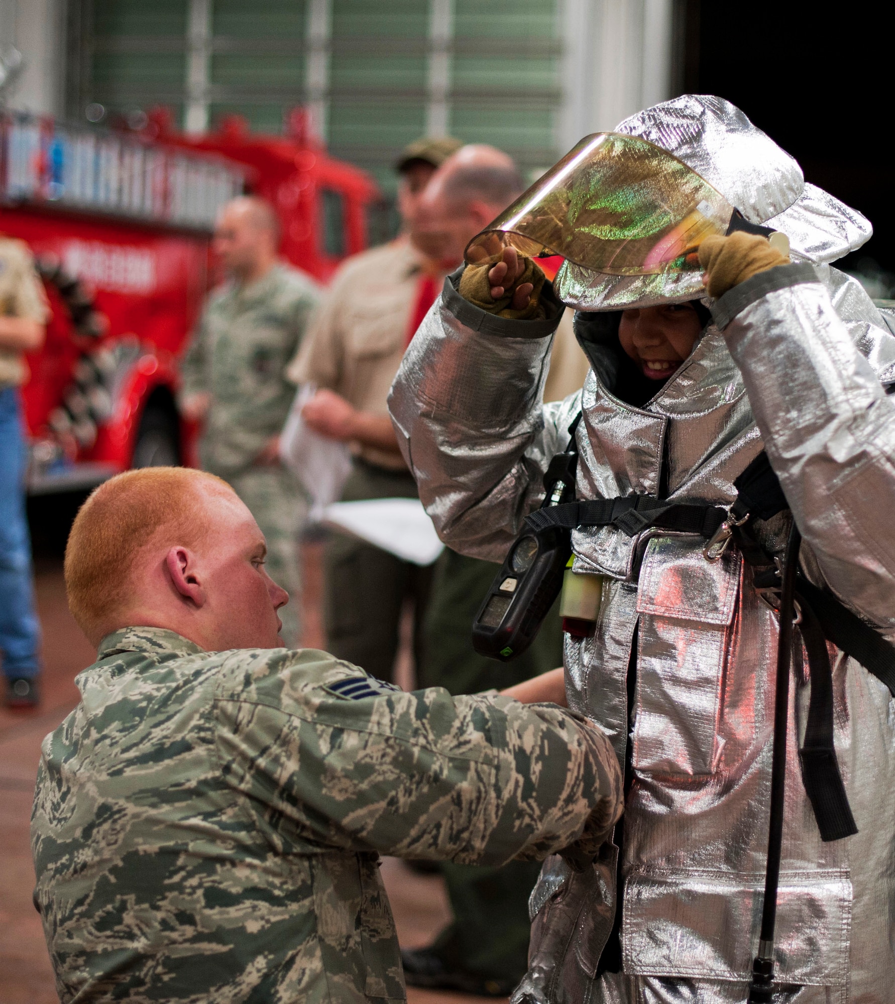 YOKOTA AIR BASE, Japan -- Senior Airman Thomas Kirts, 374th Civil Engineer Squadron firefighter, helps put turn-out gear on a scout from the Boy Scouts of America Troop 45 of Yokota Air Base, Japan, March 20, 2013, at Yokota Air Base, Japan.  The turn-out suits can withstand temperatures up to 1,200 degrees Fahrenheit. (U.S. Air Force photo by Airman 1st Class Meagan Schutter)  