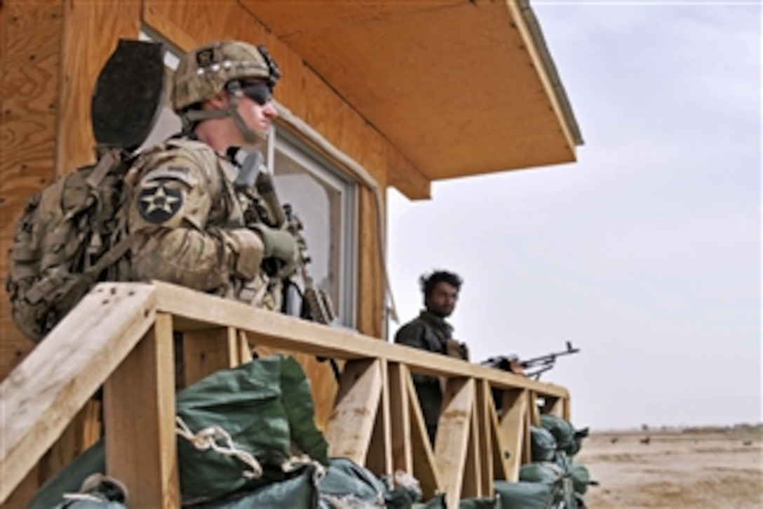 U.S. Army Pfc. Scott Frank and Afghan Uniformed Police provide security at a police checkpoint during a visit by International Security Assistance Forces in Spin Boldak District, Kandahar Province, Afghanistan, on March 19, 2013.  The soldiers were conducting an assessment of the checkpoint.  Frank is attached to the 2nd Battalion, 23rd Infantry Regiment.  