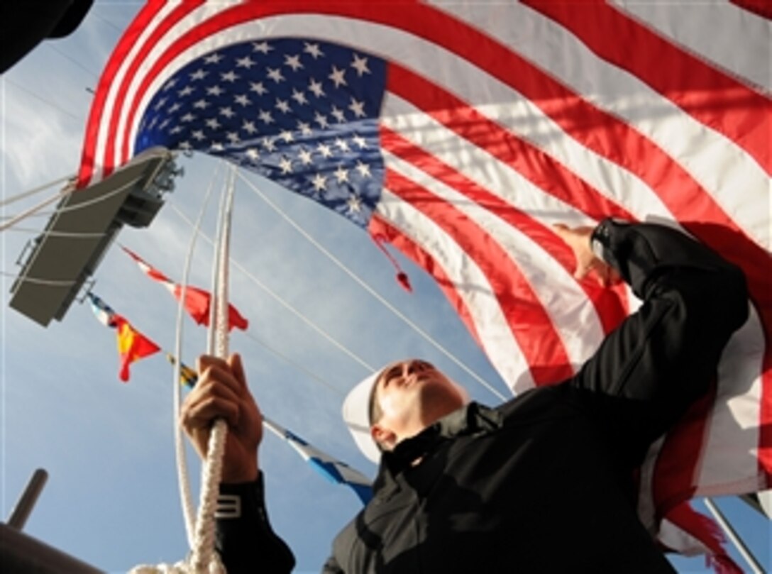 U.S. Navy Seaman Vincent Peters shifts colors on the island of the aircraft carrier USS Ronald Reagan (CVN 76) as it completes its homeport change from Bremerton, Wash., to San Diego, Calif., on March 21, 2013.  The return to San Diego follows a yearlong docking at Puget Sound Naval Shipyard and Intermediate Maintenance Facility in Bremerton, Wash.  