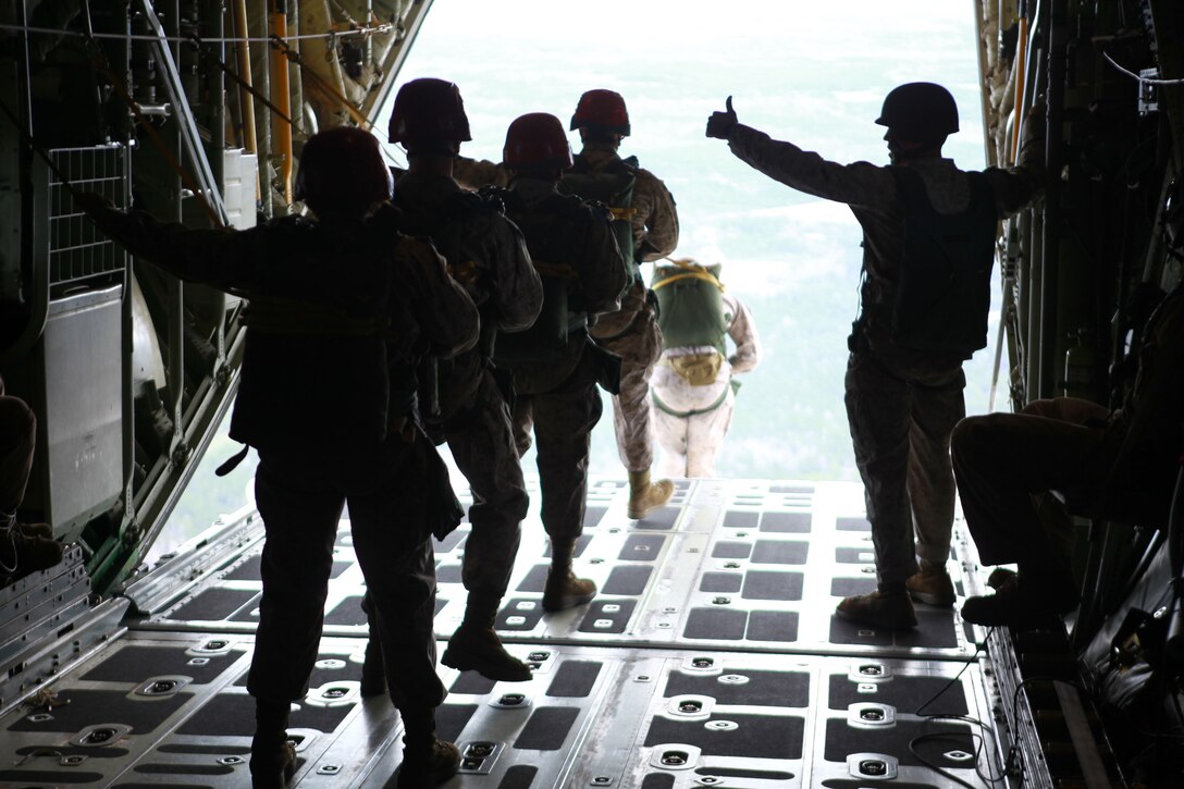 An assistant jump master gives Marines from Landing Support Company, Combat Logistics Regiment 27, 2nd Marine Logistics Group the “OK” to jump during an airborne exercise near Camp Lejeune, N.C.,  March 20, 2013. Marines jumped from a height of 1200 feet to meet their quarterly requirement. 
