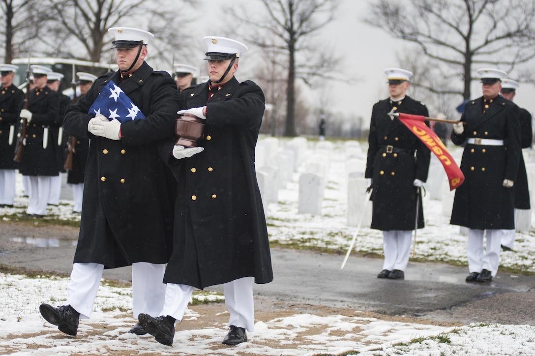 Marine Corps body bearers carry the urn and folded flag during a funeral ceremony at Arlington National Cemetery, Va., March 25.