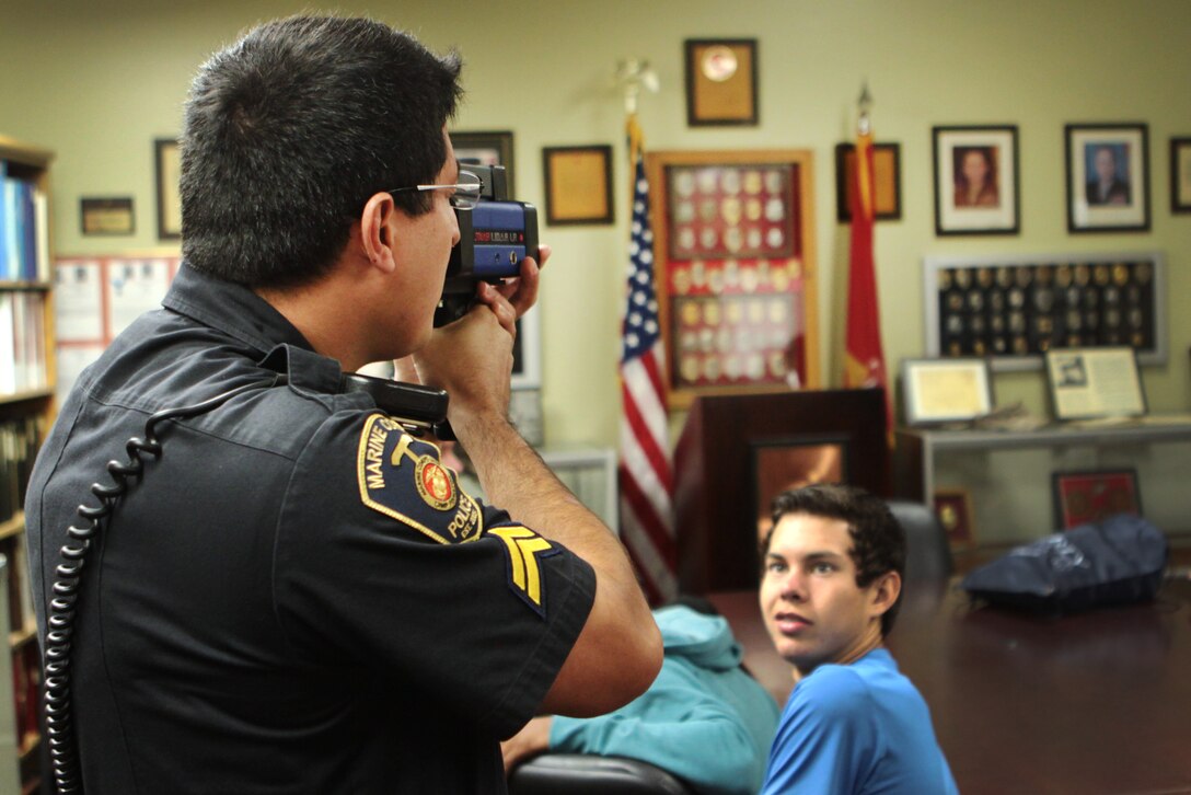 Daniel Vasquez, a civilian police officer with Security Battalion, demonstrates how to use a light detection and ranging speed radar to El Camino students interested in the law enforcement career field here, Oct. 30. The School-to-Career Program allows students to shadow experts in the career field of their choice.