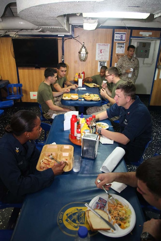 Marines and sailors on mess duty have dinner aboard USS Rushmore, March 15. The 15th Marine Expeditionary Unit is deployed as part of the Peleliu Amphibious Ready Group as a U.S. Central Command theater reserve force, providing support for maritime security operations and theater security cooperation efforts in the U.S. 5th Fleet area of responsibility. (U.S. Marine Corps photo by Cpl. Timothy R. Childers/Released)