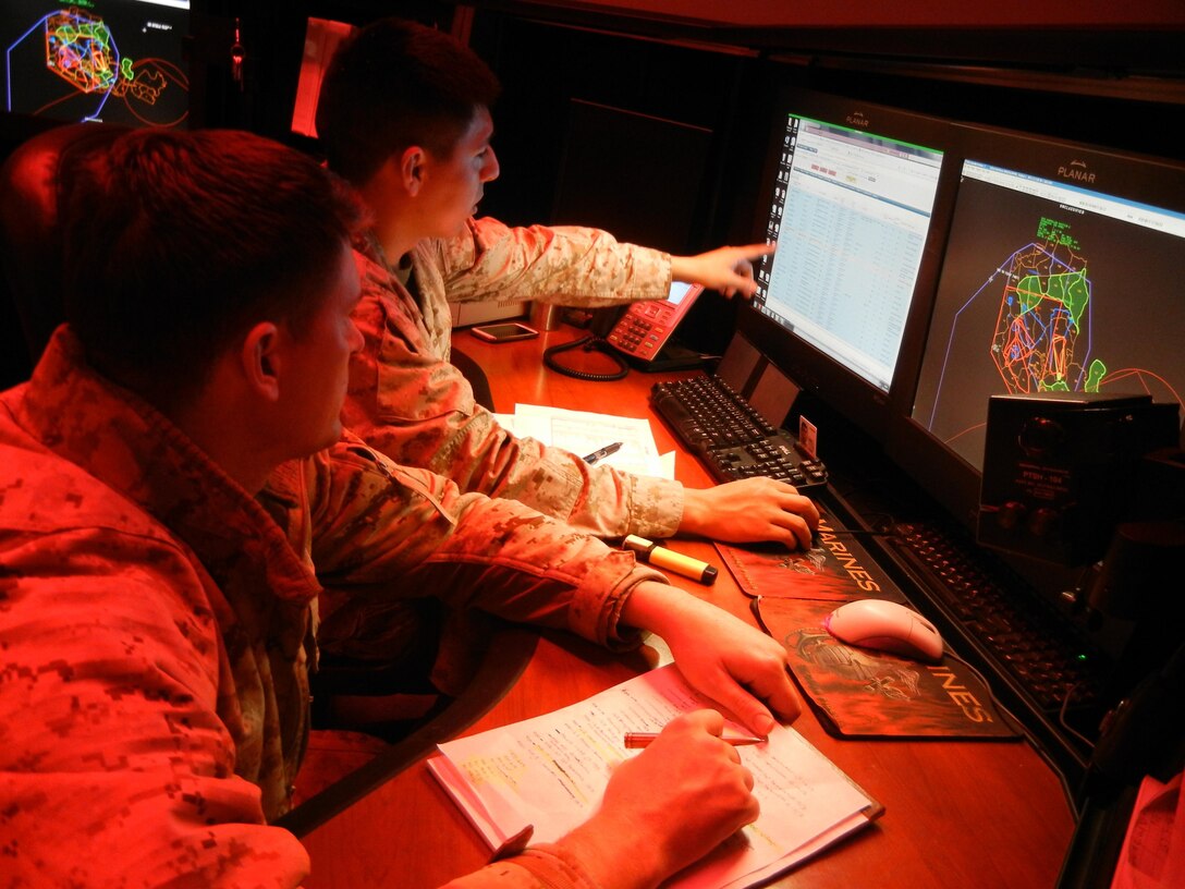 Fire desk operator Sgt. Henry Hurtado, right, briefs Cpl. Andrew Johnson, who will relieve him of his shift, on the events of the day so Johnson will be prepared for any call that might come in. 