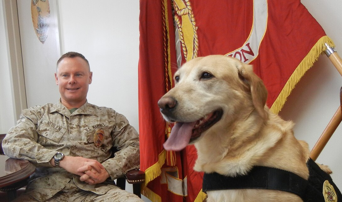 Dixie, the new mascot for Security Battalion, gets an audience in the office of Col. Barry Neulen, the battalion commanding officer, whenever she likes.