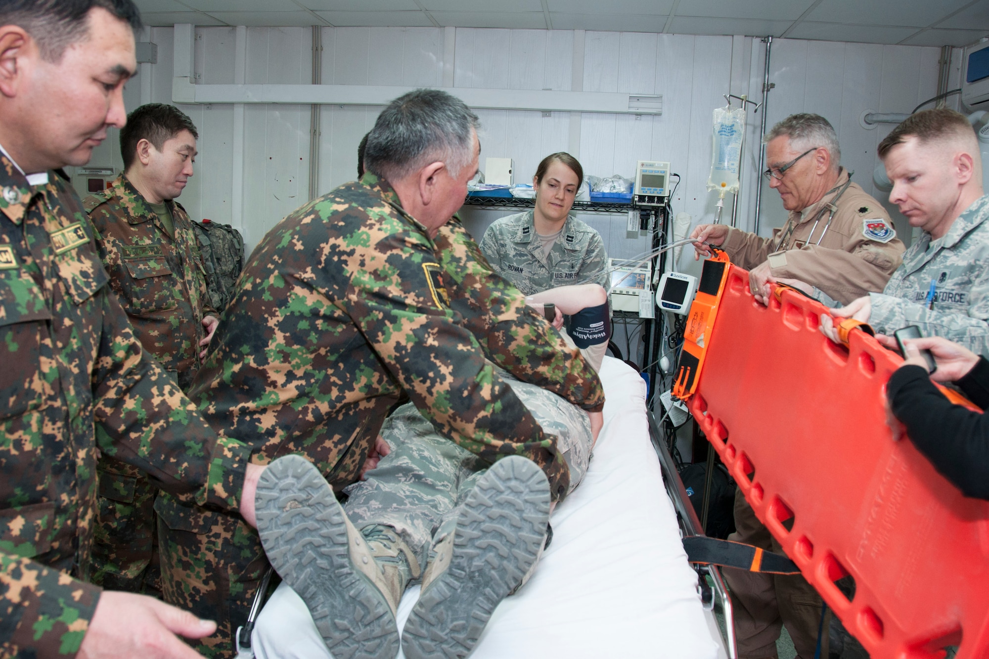 U.S. and Kyrgyz Republic military members work together to prepare a simulated patient for aeromedical evacuation as part of a military exchange March 18, 2013, at the Transit Center at Manas, Kyrgyzstan. Exchanges such as this are held on a weekly basis for the purpose of sharing information on processes and common terminology. (U.S. Air Force photo/Tech. Sgt. Rachel Martinez)