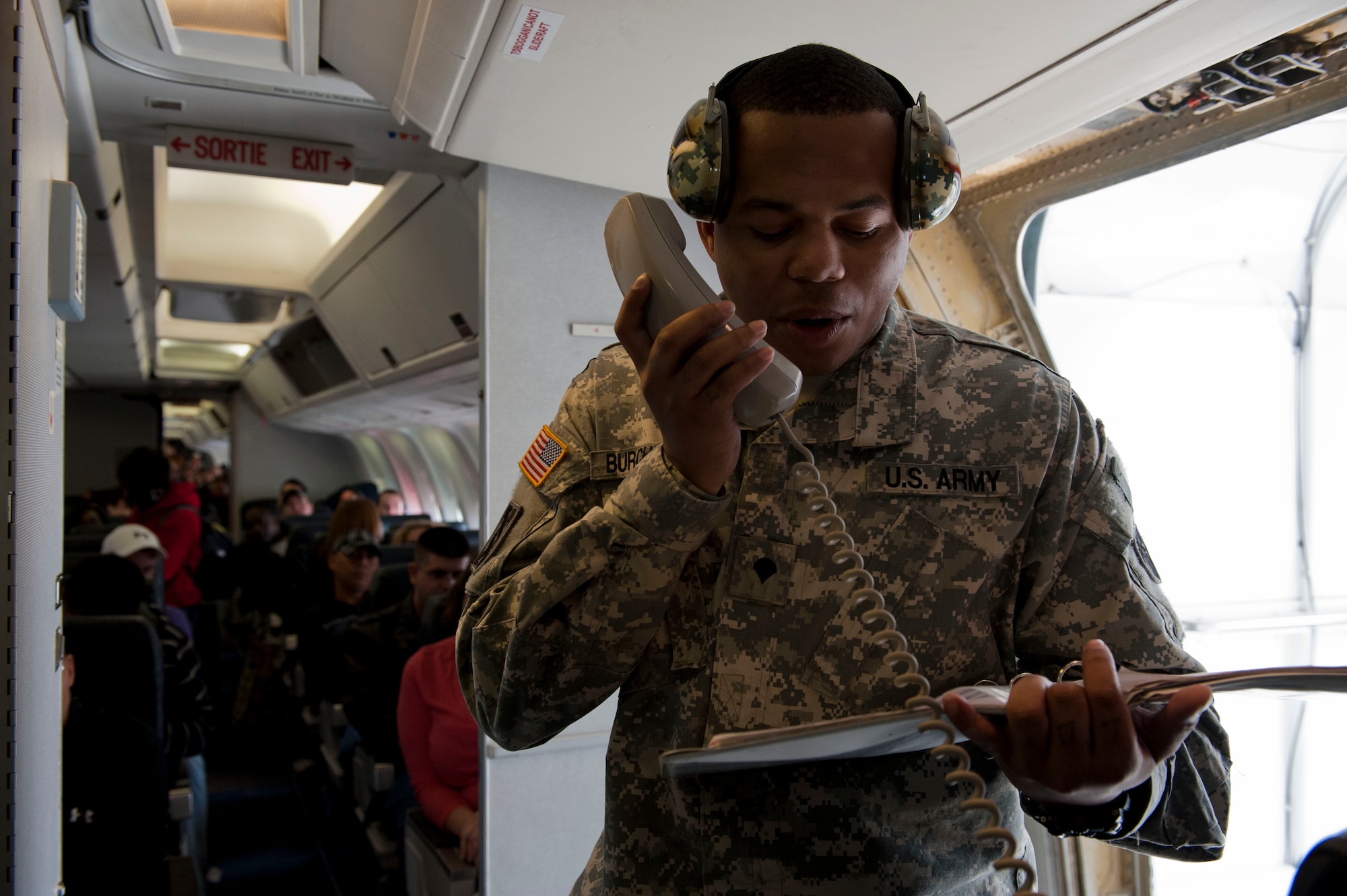 YOKOTA AIR BASE, Japan – A Soldier from the 623rd Movement Control Team, 35th Combat Sustainment Support Battalion, gives instructions to passengers at Yokota Air Base, Japan, March 20, 2013. The instructions provided passengers with safety reminders, weather updates and directions on exiting the aircraft. (U.S. Air Force photo by Airman 1st Class Meagan Schutter)
