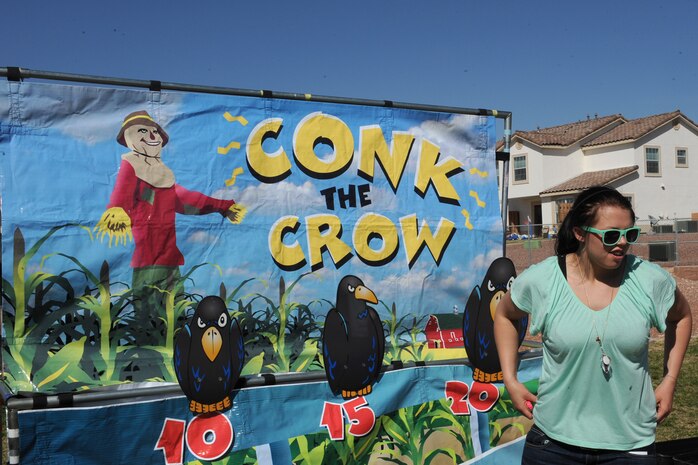 Senior Airman Tabitha Fouch, 757th Aircraft Maintenance Squadron aircraft supply journeyman, runs a "Conk the Crow" game booth during the Easter egg hunt and extravaganza March 23, 2013, at the Nellis Youth Center sports field on Nellis Air Force Base, Nev. Fouch and multiple other volunteers from Nellis helped to make the event a success. (U.S. Air Force photo by Tech. Sgt. Taylor Worley)