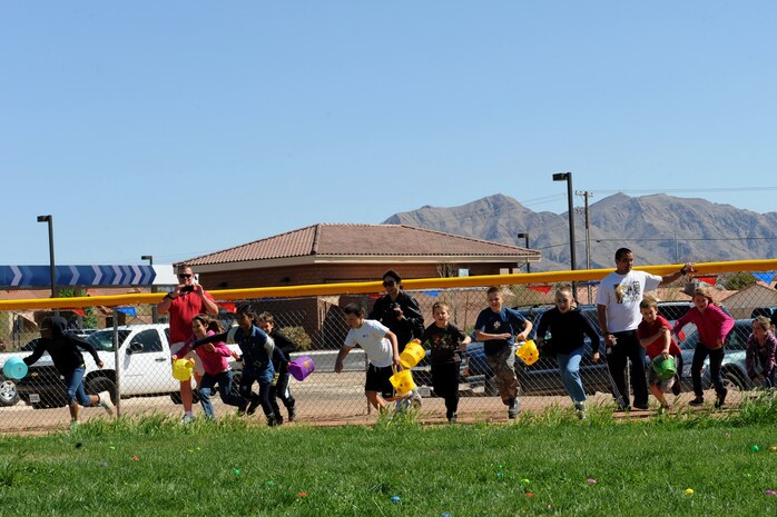 Children run onto the field at the beginning of the 9 to12 year old Easter egg hunt during the Easter egg hunt and extravaganza held at the Nellis Youth Center sports field. March 23, 2013, Nellis Air Force Base, Nev. The day included egg hunts for children 1to 2 years old, 3 to 5 years old, 6 to 8 years old and 9 to 12 years old. (U.S. Air Force photo by Tech. Sgt. Taylor Worley)