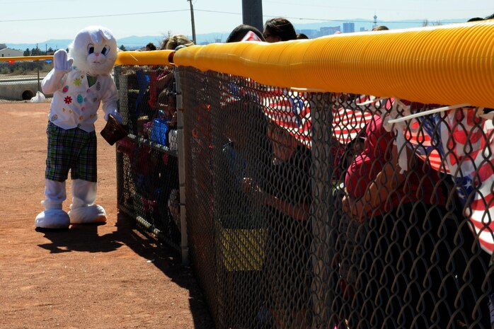 The Easter bunny waves and passes out candy to children waiting for the start of the 6 to8 year old egg hunt during the Easter egg hunt and extravaganza March 23, 2013, at the Nellis Youth Center sports field on Nellis Air Force Base, Nev. The day included egg hunts for children 1to 2 years old, 3 to 5 years old, 6 to 8 years old and 9 to 12 years old. (U.S. Air Force photo by Tech. Sgt. Taylor Worley)
