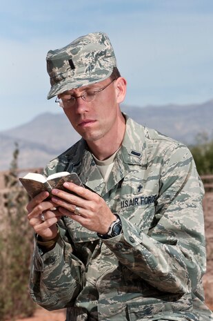 Chaplain (1st Lt.) Ammon Larson, 99th Air Base Wing Chapel, reads a Bible in the reflection garden located behind the chapel March 25, 2013, at Nellis Air Force Base, Nev. The reflection area can be used as a tool to help relieve stress. The reflection garden was built to help airmen relieve stress. (U.S. Air Force photo by Airman 1st Class Jason Couillard)