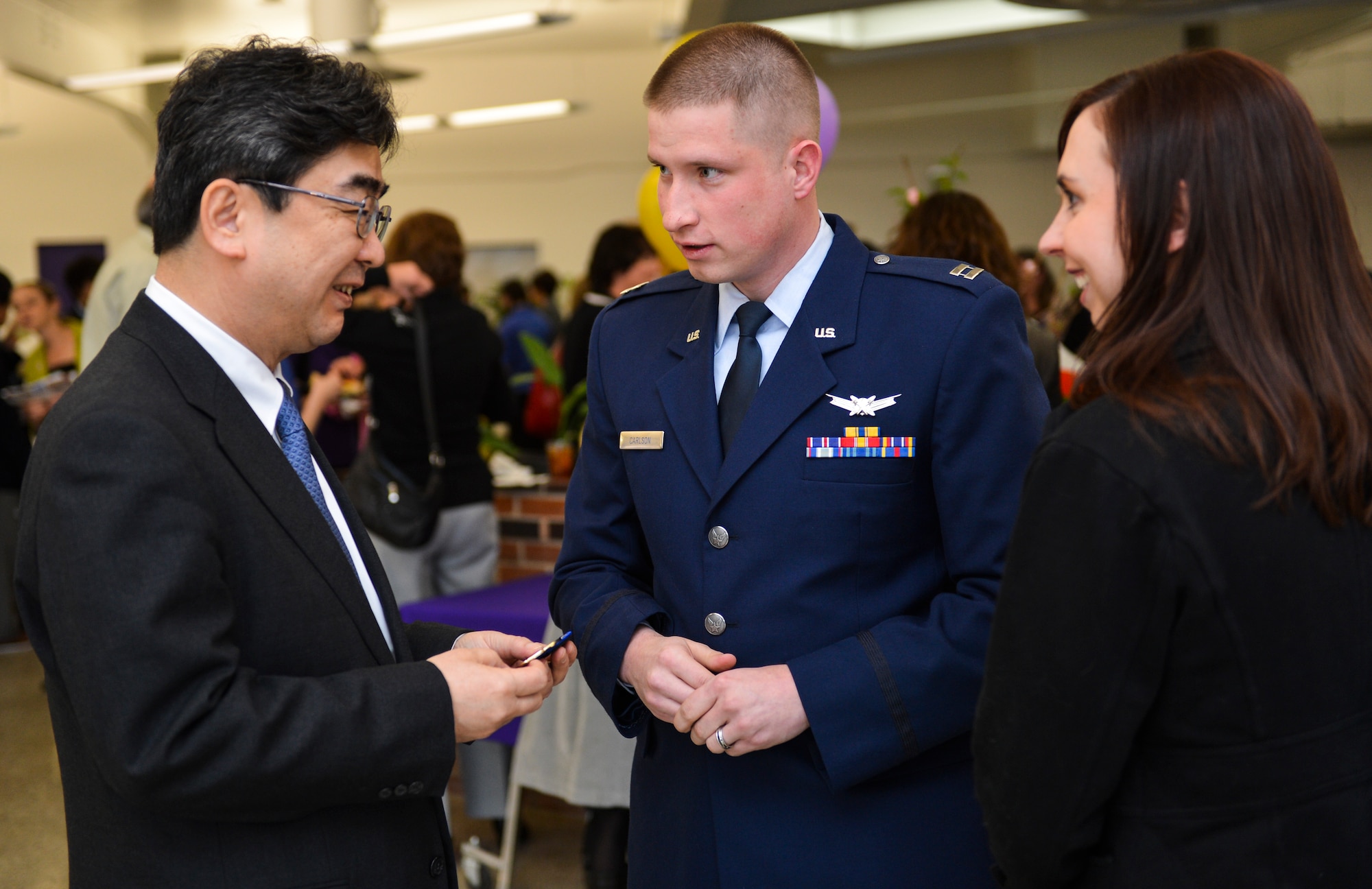 Capt. Joshua Carlson, 1st Space Operations Squadron mission commander, presents Ikuhiko Ono, Consul General of Japan, with a unit coin during his visit at a Kizuna Project event March 22, 2013, at Littleton High School, Littleton, Colo. The event was hosted so the Consul General of Japan could thank military service members who participated in Operation Tomodachi. Operation Tomodachi was a relief mission conducted in Japan following the 2011 earthquake and tsunami disaster. (U.S. Air Force photo by Senior Airman Paul Labbe/Released)