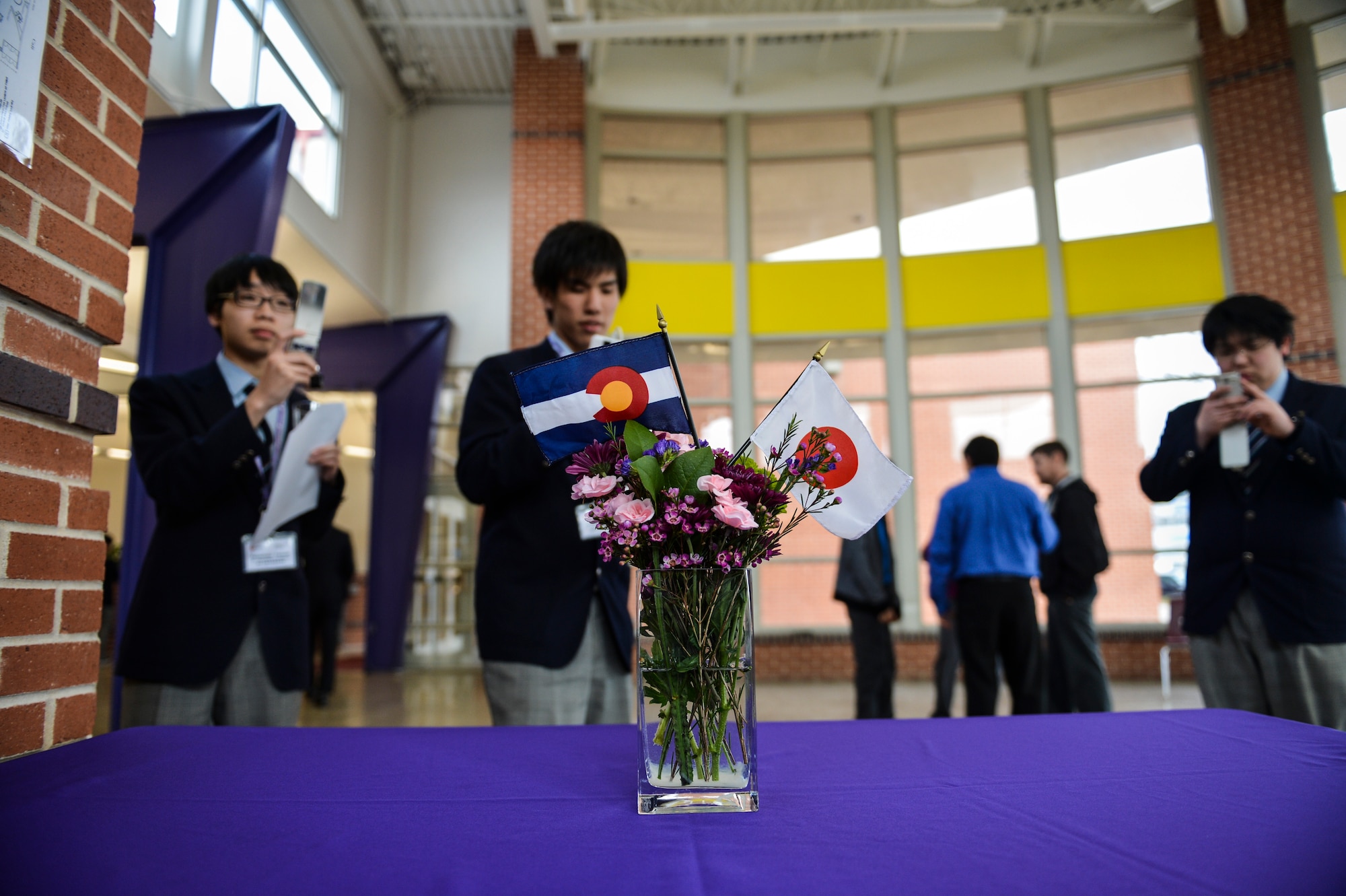25 Japanese students from Sendai, Japan take a photo of the Japanese flag and Colorado state flag March 22, 2013, at Littleton High School, Littleton, Colo. The students from Japan came to convey a message of appreciation to military service members and others who extended assistance to Japan after the tsunami. (U.S. Air Force photo by Senior Airman Paul Labbe/Released)