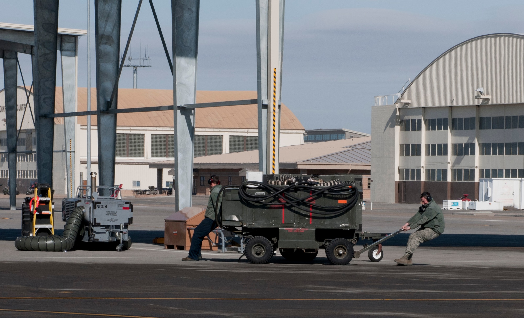 U.S. Air Force Airmen move a piece of equipment before an F-15E Strike Eagle takes flight, Feb. 28, 2013, at Mountain Home Air Force Base, Idaho. More than one Airman is needed to transport this equipment due to its large size. (U.S. Air Force photo/Senior Airman Heather Hayward)