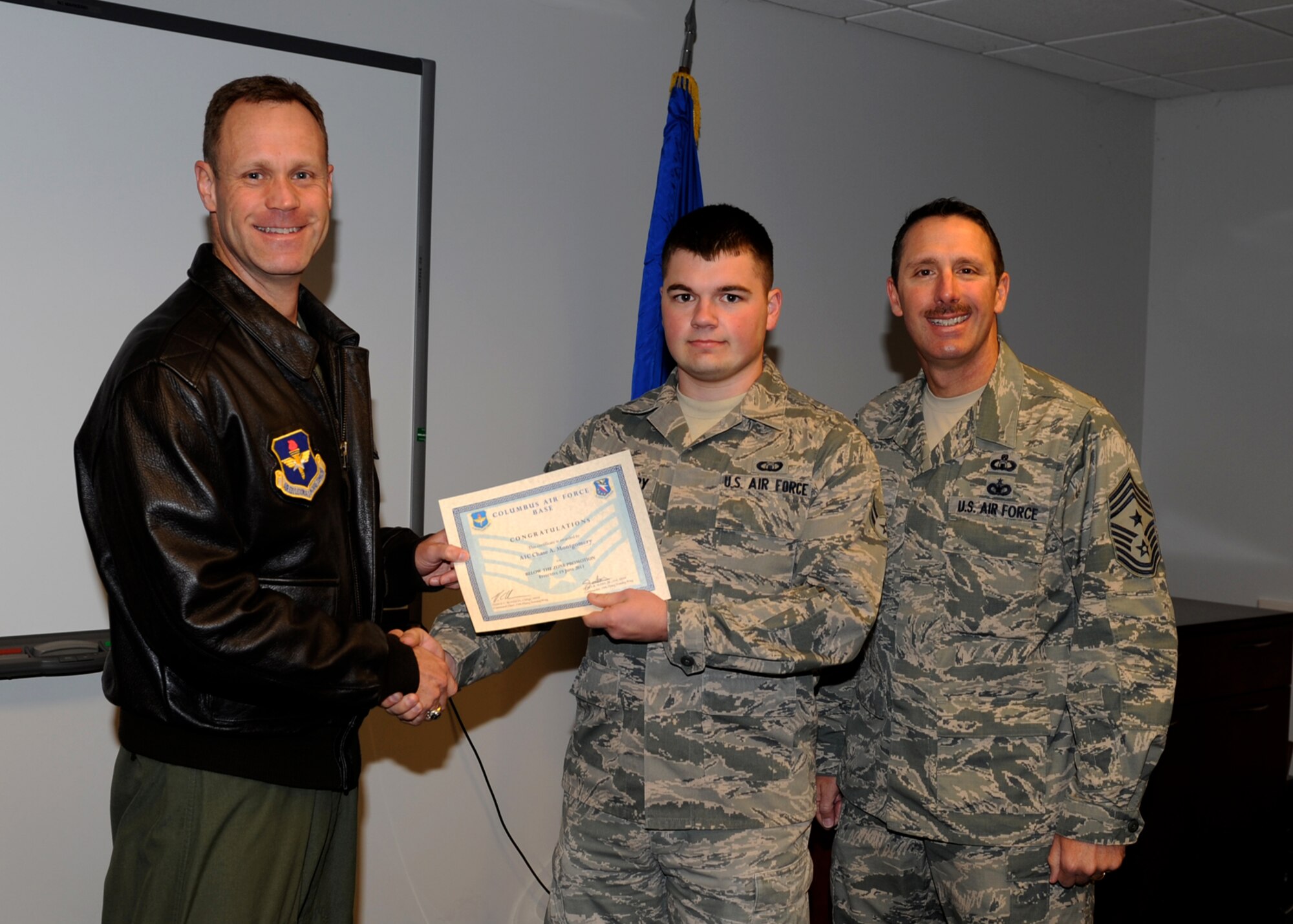 Airman 1st Class Nathaniel Farinas, 14th Medical Operations Squadron is awarded senior airman Below-The-Zone by Col. Jim Sears, 14th Flying Training Wing Commander and Chief Master Sgt. Vance Kondon, 14th FTW Command Chief. (U.S. Air Force Photo/Elizabeth Owens)
