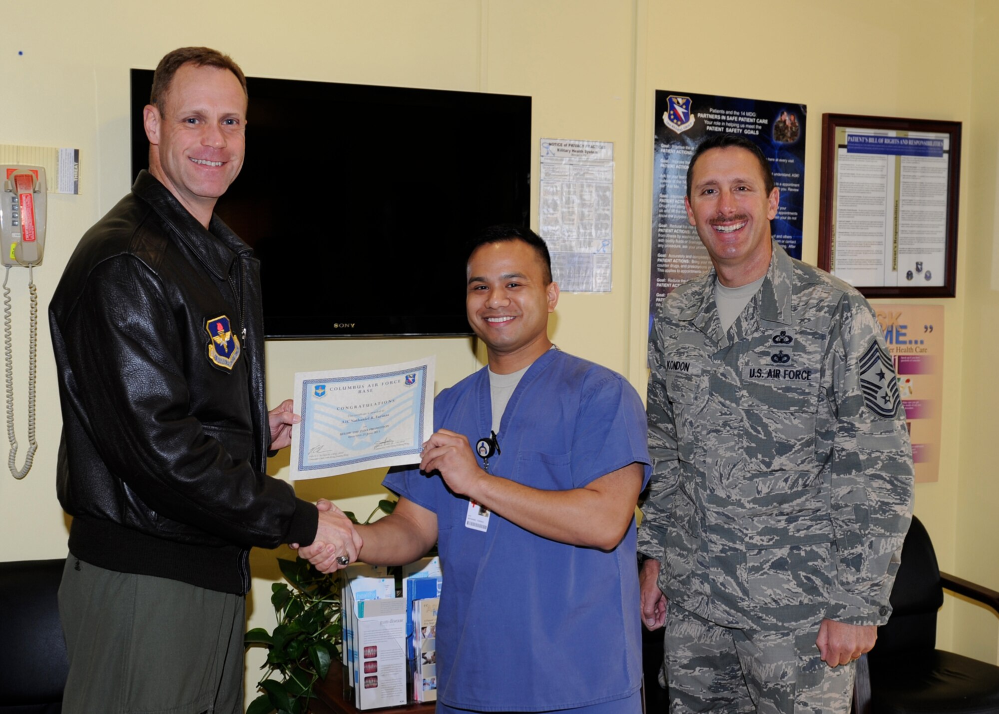 Airman 1st Class Chase Montgomery, 14th Operations Support Squadron is awarded senior airman Below-The-Zone by Col. Jim Sears, 14th Flying Training Wing Commander and Chief Master Sgt. Vance Kondon, 14th FTW Command Chief. (U.S. Air Force Photo/Elizabeth Owens)