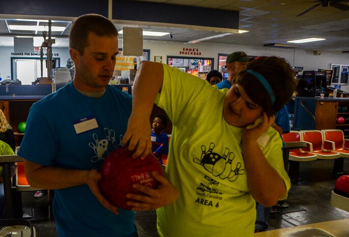 Senior Airman Chris Scott, 628th Civil Engineering Squadron utilities craftsman, helps a Special Olympian get ready to bowl during the Special Olympics South Carolina Area 6 Bowling Event March 22, 2013, in West Ashley, S.C. More than 15 Airmen and civilians from Joint Base Charleston volunteered to assist 35 middle school students. The children were from Zucker Middle School, Morningside Middle School, Fort Johnson Middle School and St. Andrews Middle School. (U.S. Air Force Photo/Airman 1st Class Jared Trimarchi) 