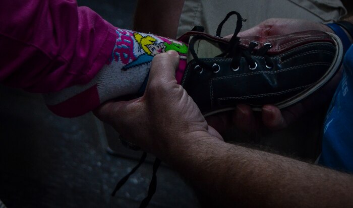 John Downey, spouse of Master Sgt. Dawn Downey,628th Medical Group, helps a Special Olympian put on a bowling shoe during the Special Olympics South Carolina Area 6 Bowling Event March 22, 2013, in West Ashley, S.C. More than 15 Airmen and civilians from Joint Base Charleston volunteered to assist 35 middle school students. The children were from Zucker Middle School, Morningside Middle School, Fort Johnson Middle School and St. Andrews Middle School. (U.S. Air Force Photo/Airman 1st Class Jared Trimarchi) 