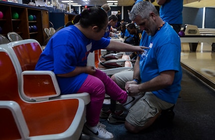 John Downey, spouse of Master Sgt. Dawn Downey, 628th Medical Group, helps untie a bowling shoe of a Special Olympian during the Special Olympics South Carolina Area 6 Bowling Event March 22, 2013, in West Ashley, S.C. More than 15 Airmen and civilians from Joint Base Charleston volunteered to assist 35 middle school students. The children were from Zucker Middle School, Morningside Middle School, Fort Johnson Middle School and St. Andrews Middle School. (U.S. Air Force Photo/Airman 1st Class Jared Trimarchi) 