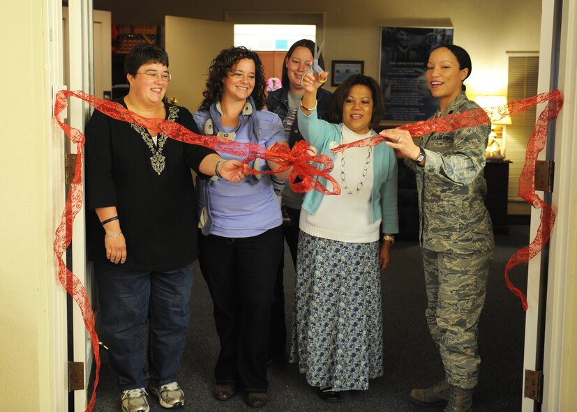 Lt. Col. Naomi Welcome, 7th Force Support Squadron commander, right, and a group of volunteers cut a ribbon during the opening ceremony of the Airman’s Attic March 26, 2013, at Dyess Air Force Base, Texas.  The Airman’s Attic, which was formerly located in the Airman and Family Readiness Center, relocated to the Hanger Center. (U.S. Air Force photo by Airman 1st Class Cierra Presentado/Released)