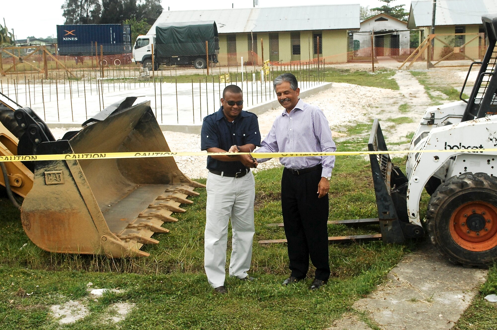 Vinai Thummalapally, U.S. ambassador to Belize, and Patrick Faber, Belize minister of education, youth and sports, cut the ribbon during the New Horizons 2013 opening ceremony March 25, 2013, at Ladyville Technical High School. New Horizons is an exercise led by U.S. Southern Command that provides medical and dental treatment as well as constructs school structures throughout Belize. It gives U.S., Belizean and Canadian service members the opportunity to train side-by-side in an exercise setting, in order to be prepared to meet future challenges when and where needed. (U.S. Air Force photo/Master Sgt. James Law)