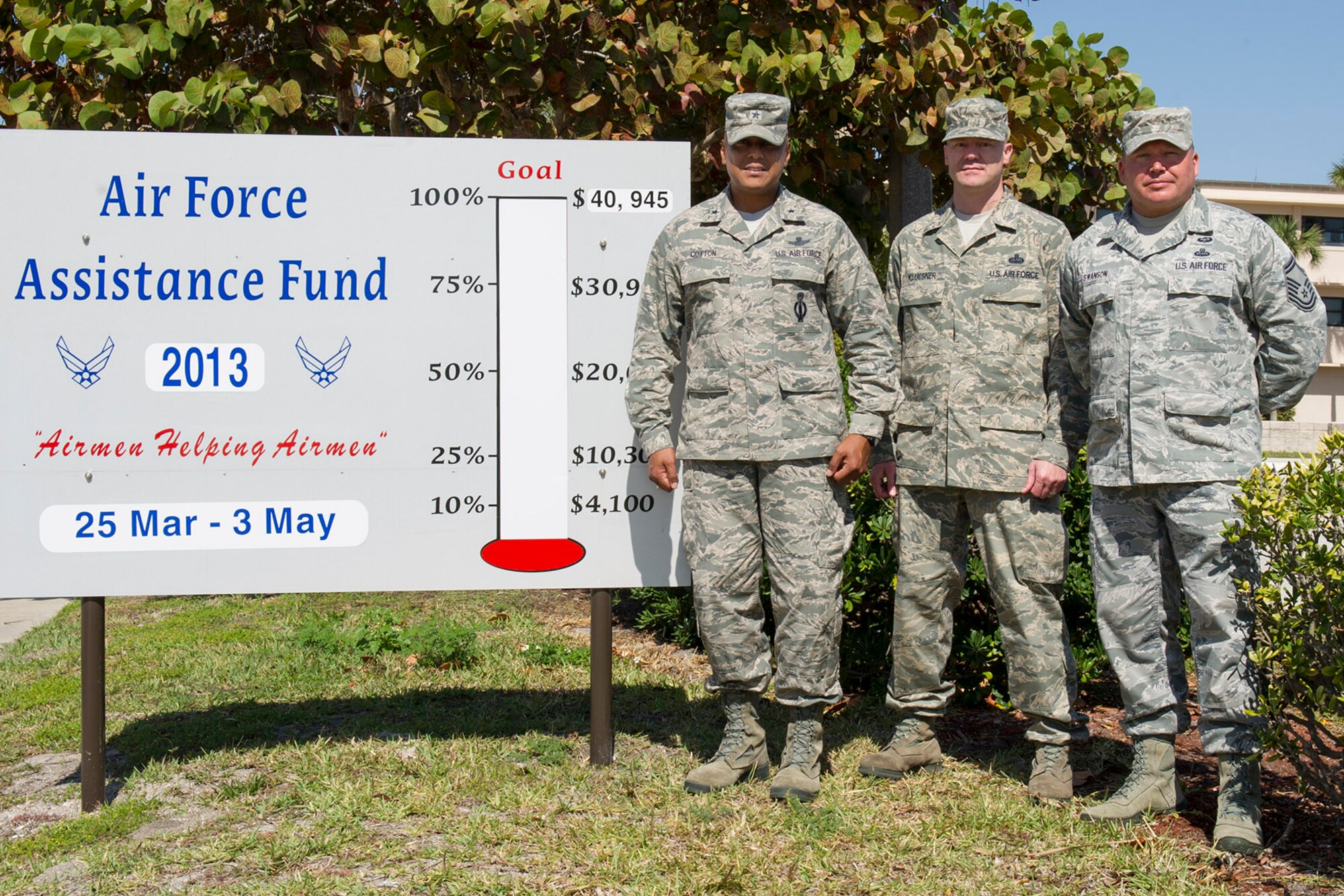 Brig. Gen. Anthony Cotton, 45th Space Wing commander, and Air Force
Assistance Fund Project Officers Master Sgt. Jeffrey Kluesner and Senior
Master Sgt. Michael Swanson gather near the AFAF campaign tracking sign near
the main gate.  The thermometer will show progress toward the installation
goal as the campaign continues through May 3. (Photo by Cory Long)
