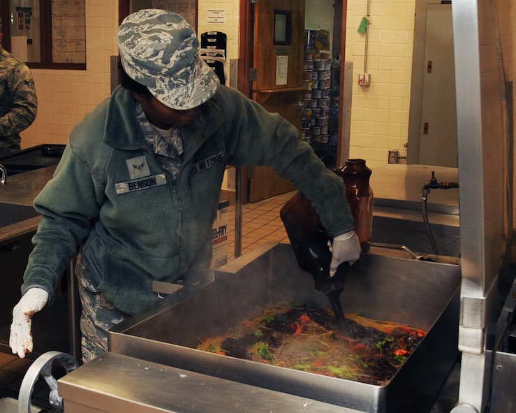 Airman 1st Class Neosha Benton, 307th Force Support Squadron food service specialist, prepares a meal at the Red River Dining Facility on Barksdale Air Force Base, La., March 26. The DFAC's line staff includes active duty personnel and contractors who are trained to prepare and serve healthy meals every day. (U.S. Air Force photo/Senior Airman Sean Martin)
