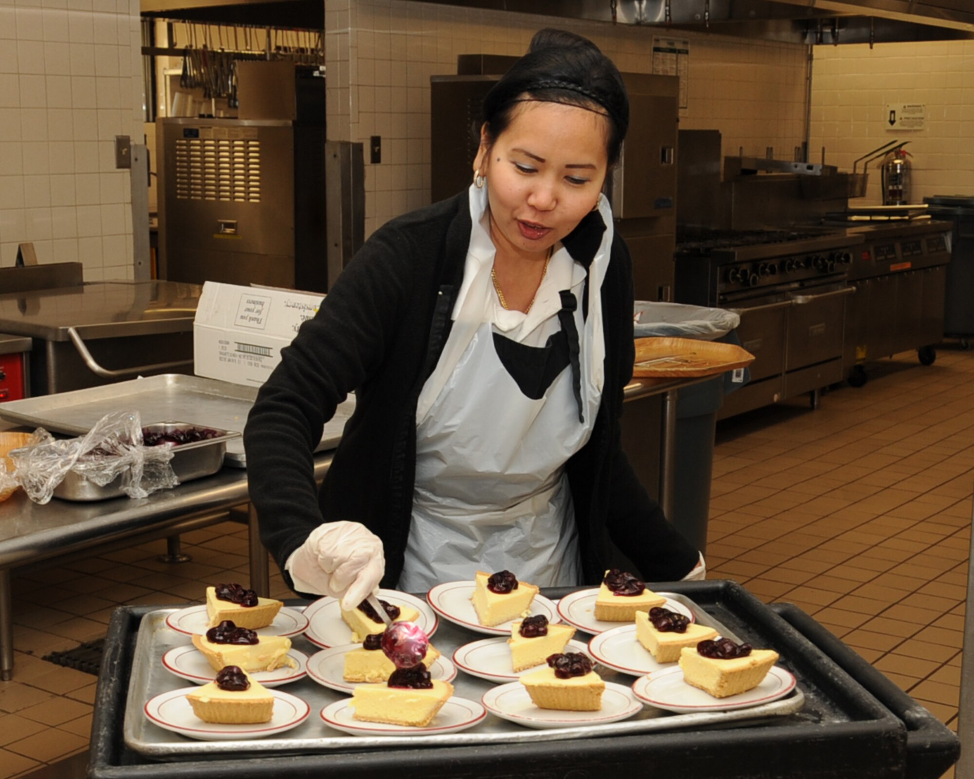 Melani Laffitte, 2nd Force Support Squadron food service specialist, adds toppings to slices of pie at the Red River Dining Facility on Barksdale Air Force Base, La., March 26. The DFAC offers a breakfast, lunch, dinner and midnight meal and is available to all enlisted personnel, commanders, squadron section commanders, retirees and their immediate family members, Department of Defense civilians in temporary duty status with a meal portion of per diem and all immediate family members of deployed personnel. (U.S. Air Force photo/Senior Airman Sean Martin)
