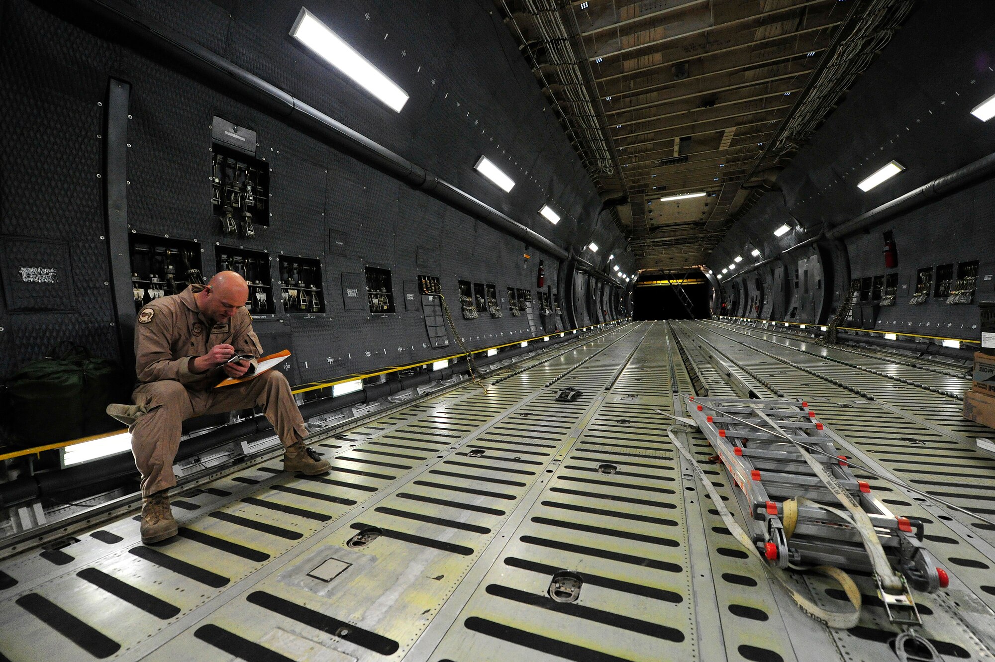 U.S. Air Force Master Sgt. Benjamin Fay, a C-5M Super Galaxy loadmaster with the 436th Airlift Wing at Dover AFB, Del., inspects a load planning document before loading U.S. Army shipping containers here Jan. 28, 2013. The aircraft is assigned to support the scheduled rotation of two U.S. Army aviation task forces. (U.S. Air Force photo by Tech Sgt. Parker Gyokeres)