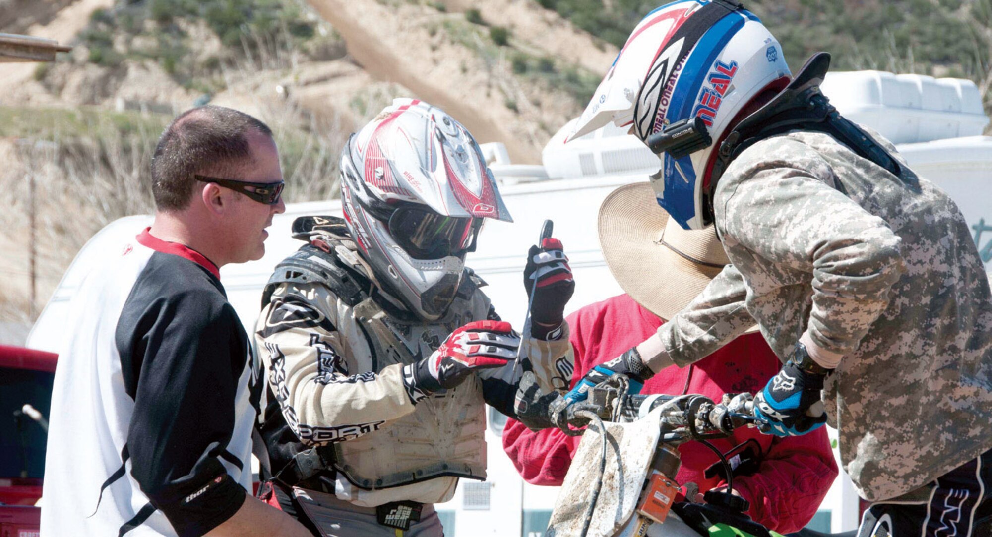 The California National Guard competed at the Southern California Glen Helen Raceway, in a six-hour motocross endurance relay race, March 10. Maj. Jon Dahl, 147th Combat Communications Squadron, hands over the team’s dirt bike to Chief Master Sgt. Gregory Garcia, 163d Aircraft Maintenance Squadron, for continued nonstop racing action. Master Sgt. Eric Viamonte, 163d AMXS and Staff Sgt. Stephen Bucaro, 147th CCS, shown making mechanical adjustments to the bike. (Air National Guard photo by Master Sgt. Julie Avey)