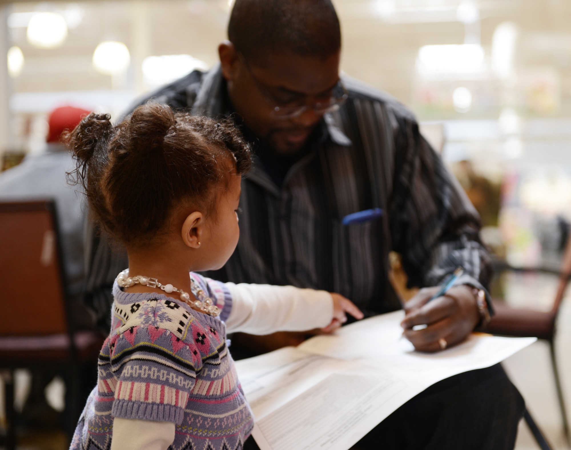 Cynthia Brown, daughter of U.S. Staff Sgt. Amanda Brown, Detachment 1, 31st Intelligence Squadron tactical linguist, and Daniel Brown, point to sections of the C.W. Bill Young Department of Defense marrow donor program registration form her father was filling out at the Exchange, Shaw Air Force Base, S.C., March 22, 2013. During the week of March 18, 1,195 Team Shaw members registered for the C.W. Bill Young DoD marrow donor program to help save lives of those in need of bone marrow and/or stem cells. (U.S. Air Force photo Senior Airman Tabatha Zarrella/Released)