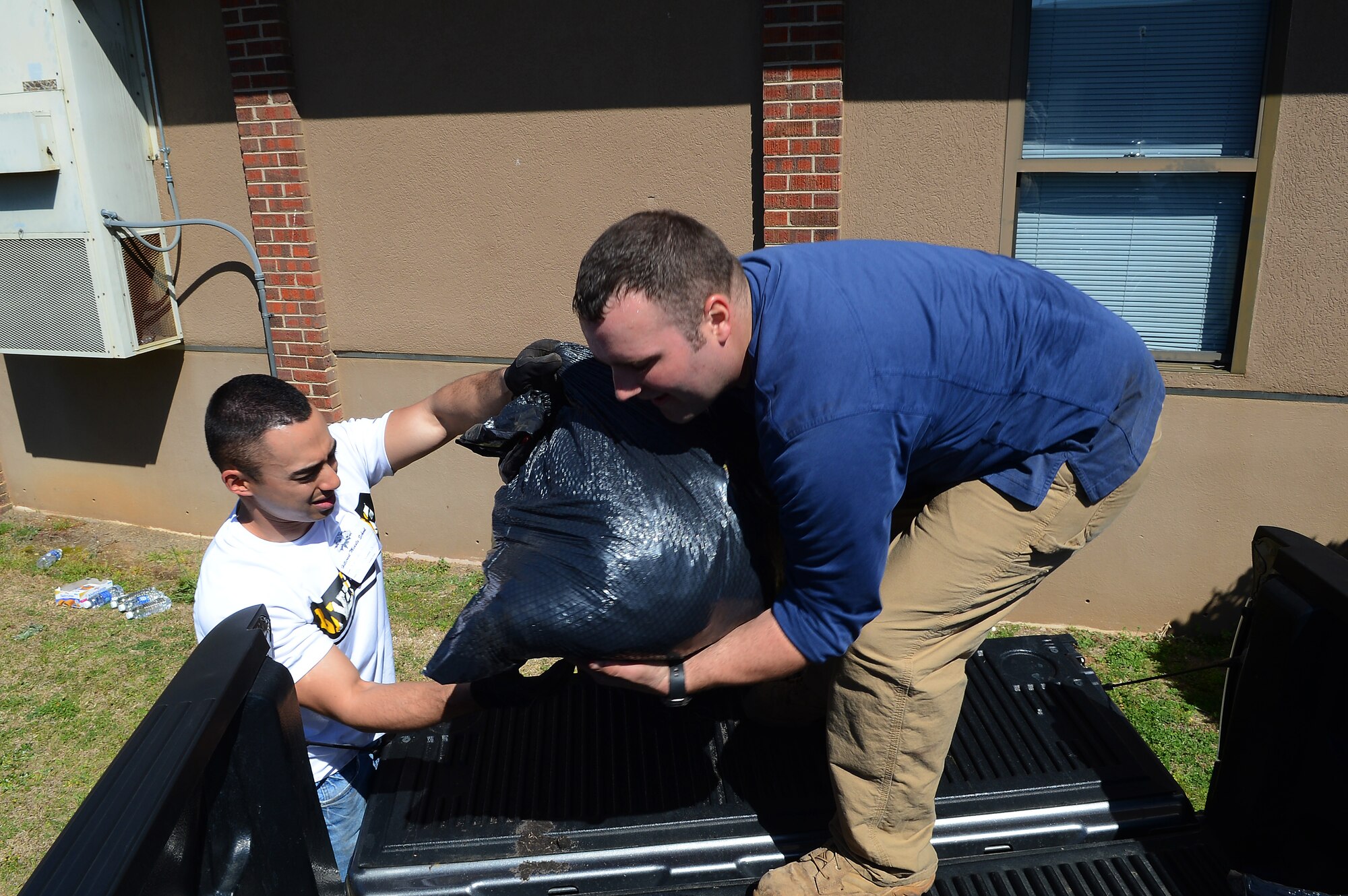 U.S. Air Force Senior Airman Kyle Albrecht and Senior Airman Matthew Altfillisch, both assigned to the 20th Civil Engineer Squadron load garbage bags filled with weeds into a truck bed at Hillcrest Middle School, Sumter, S.C., March 19, 2013.  (U.S. Air Force photo by Airman 1st Class Nicole Sikorski/Released)