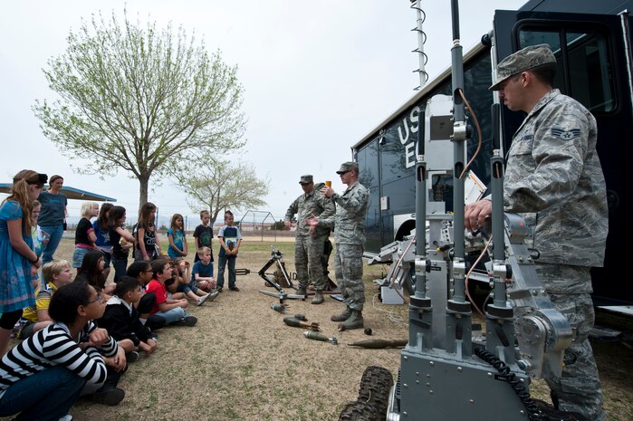 Airmen from the 99th Civil Engineer Squadron Explosive Ordnance Disposal, tell children at Lomie Heard Elementary school about their job and the equipment they use to dispose of ordnance March 20, 2013, at Nellis Air Force Base, Nev. The Airmen displayed various types of ordnance seen and equipment used while doing their job. (U.S. Air Force photo by Airman 1st Class Jason Couillard)