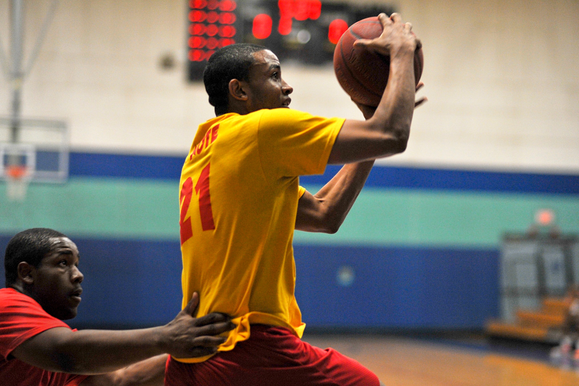 GOODFELLOW AIR FORCE BASE, Texas -- Corey Pasely, 17th Medical Operations Squadron, jumps to the goal for a lay-up while Brandon Roberts, 169th Engineer Battalion student, defends during the 3-on-3 March Madness Basketball Tournament at Mathis Fitness Center, March 22. The 15 teams faced head to head in a double elimination tournament with 15 minutes on the clock to see who would win it all. (U.S. Air Force photo/ Airman 1st Class Michael Smith)